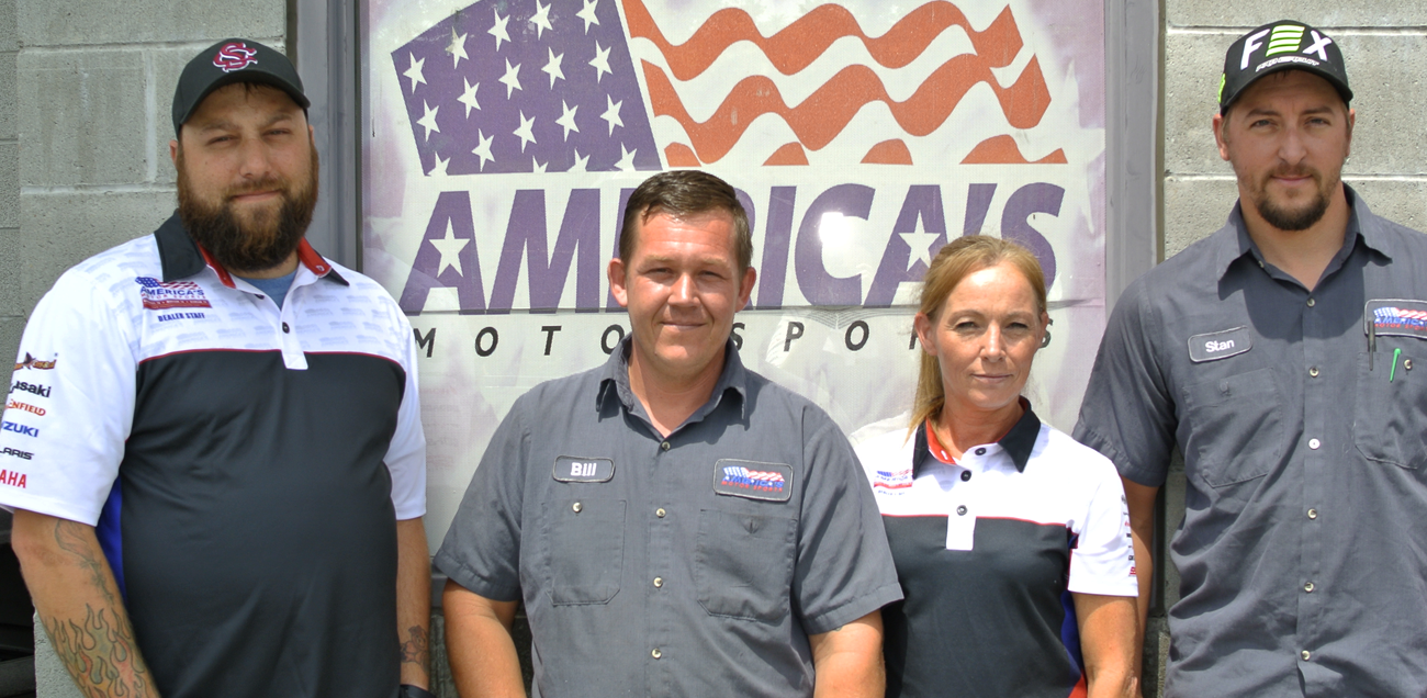 Four America's Motor Sports Nashville service center staff members standing in front of a brick wall